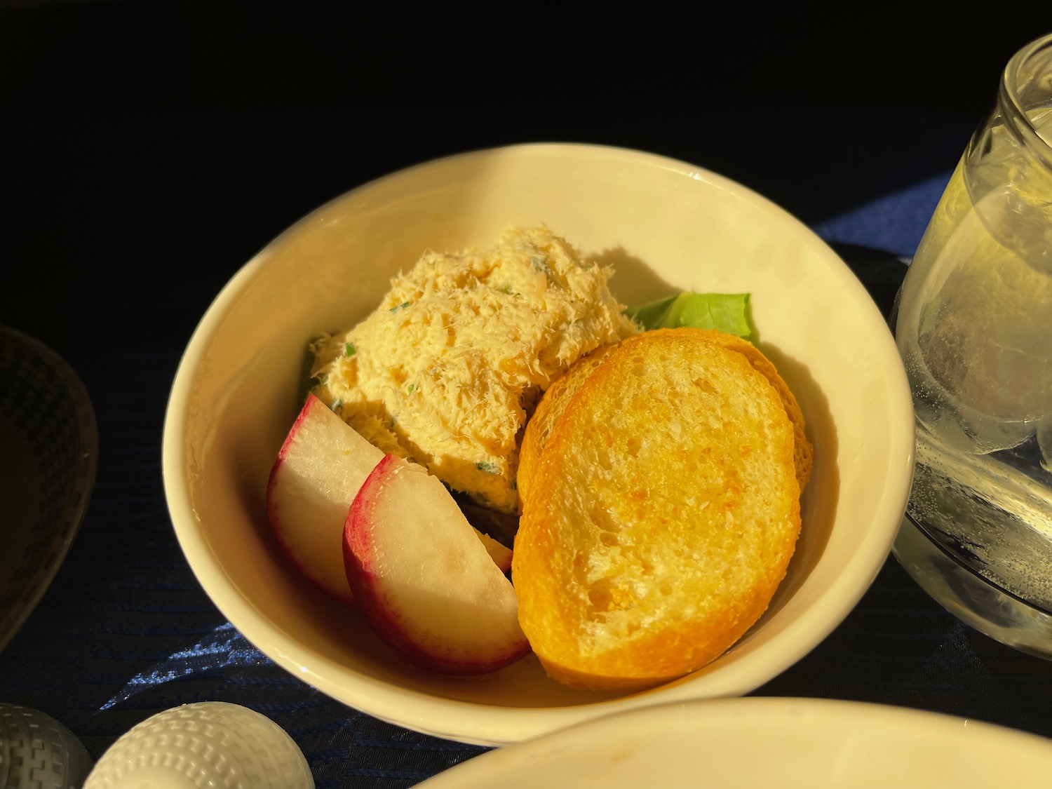 a bowl of food with a slice of bread and a slice of radish