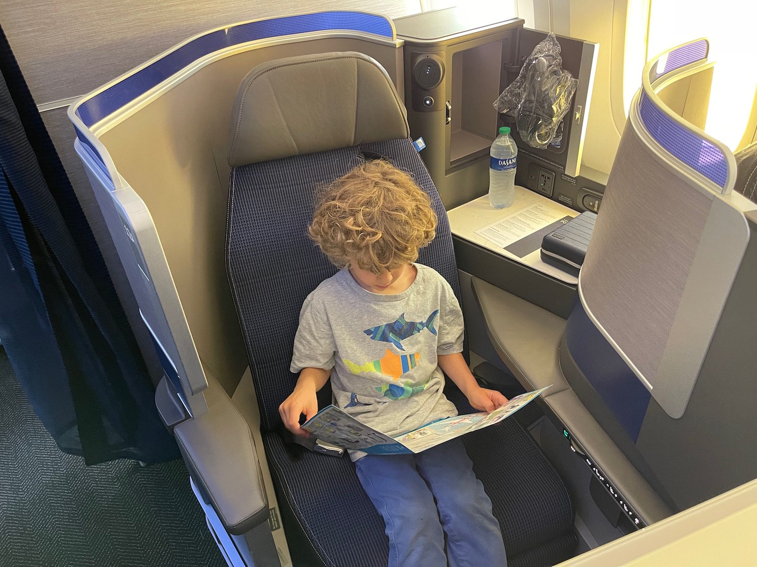 a child sitting in a chair reading a map