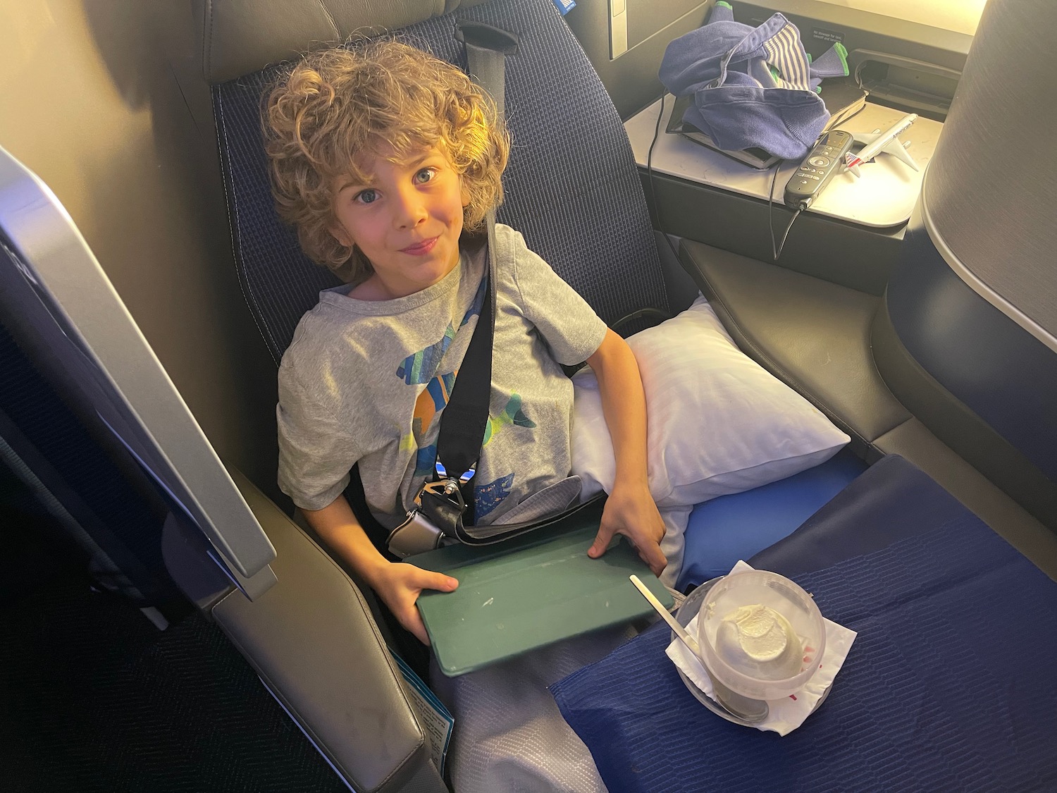 a boy sitting in a seat with a tray