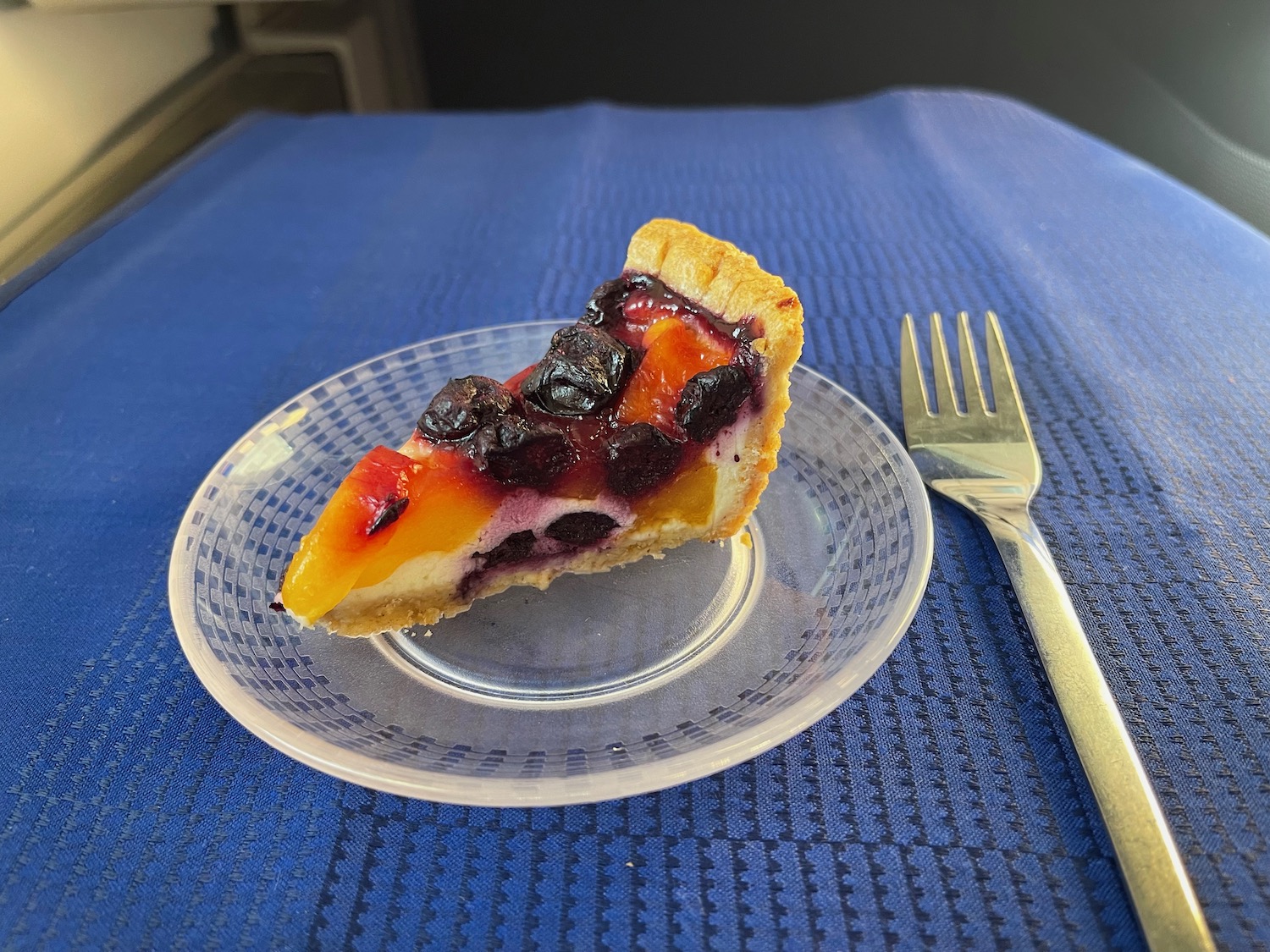 a slice of fruit pie on a plate with a fork