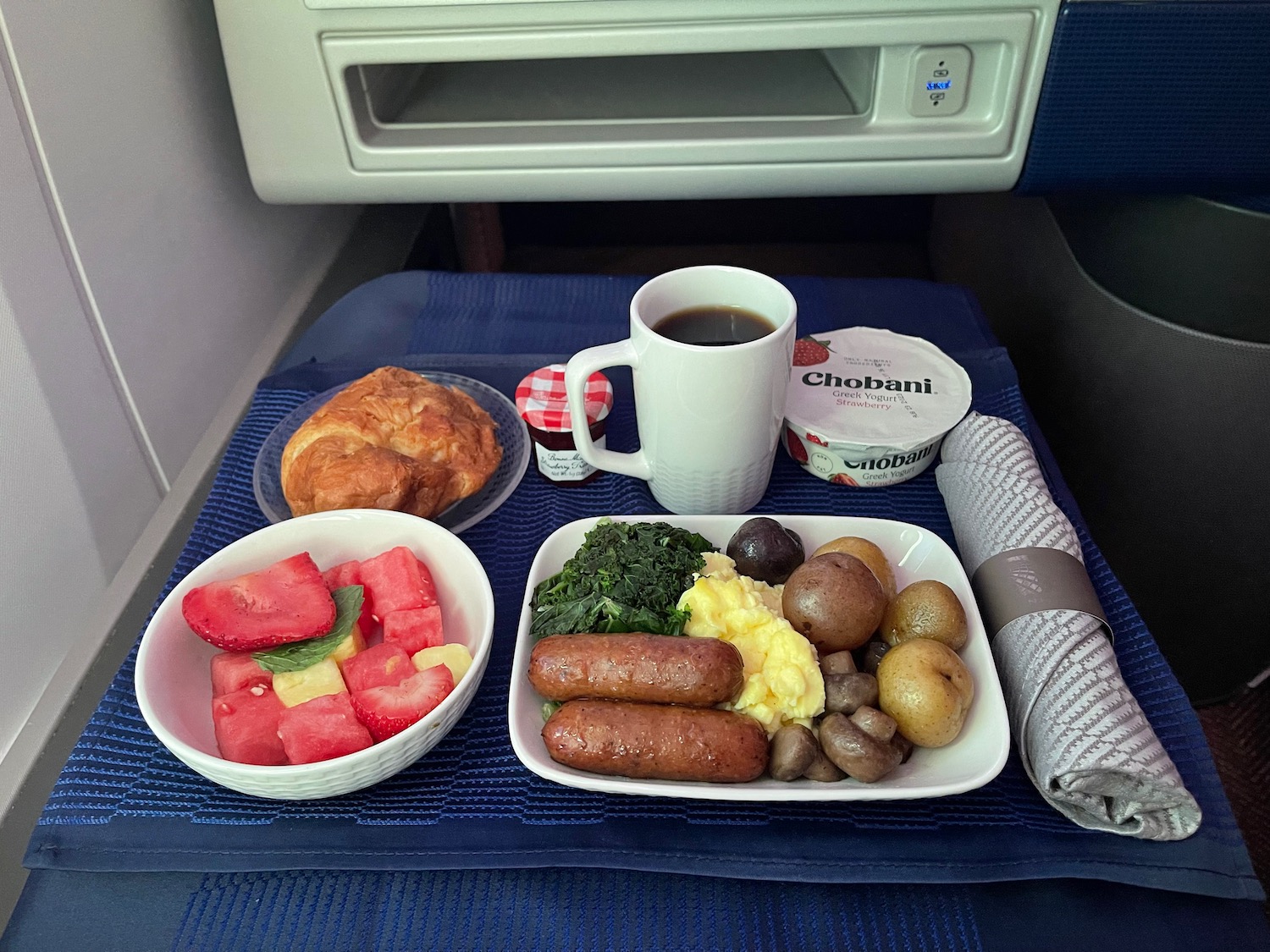 a plate of food and a cup of coffee on a blue mat