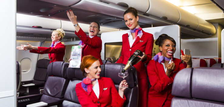 a group of women in red uniforms on an airplane