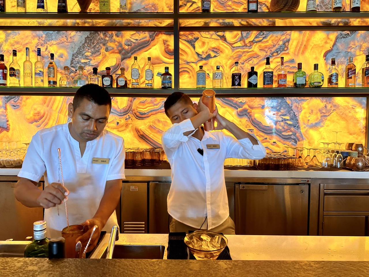 two men in white shirts at a bar