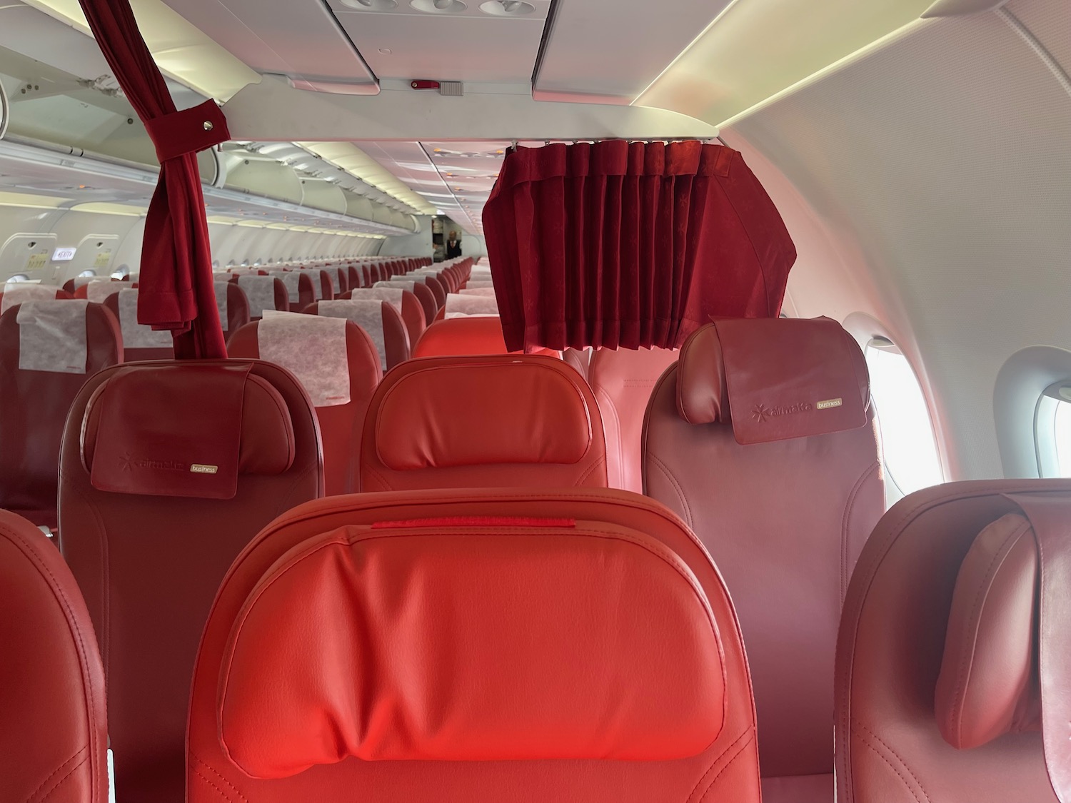 the inside of an airplane with red seats