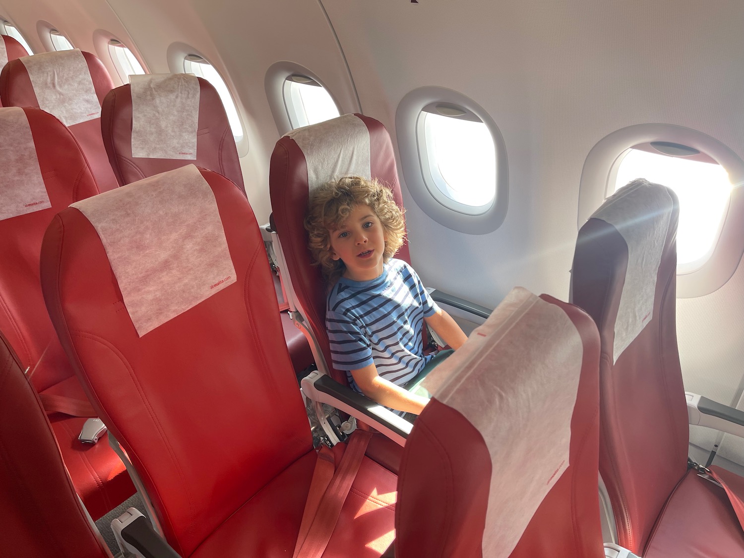 a boy sitting in a chair on an airplane