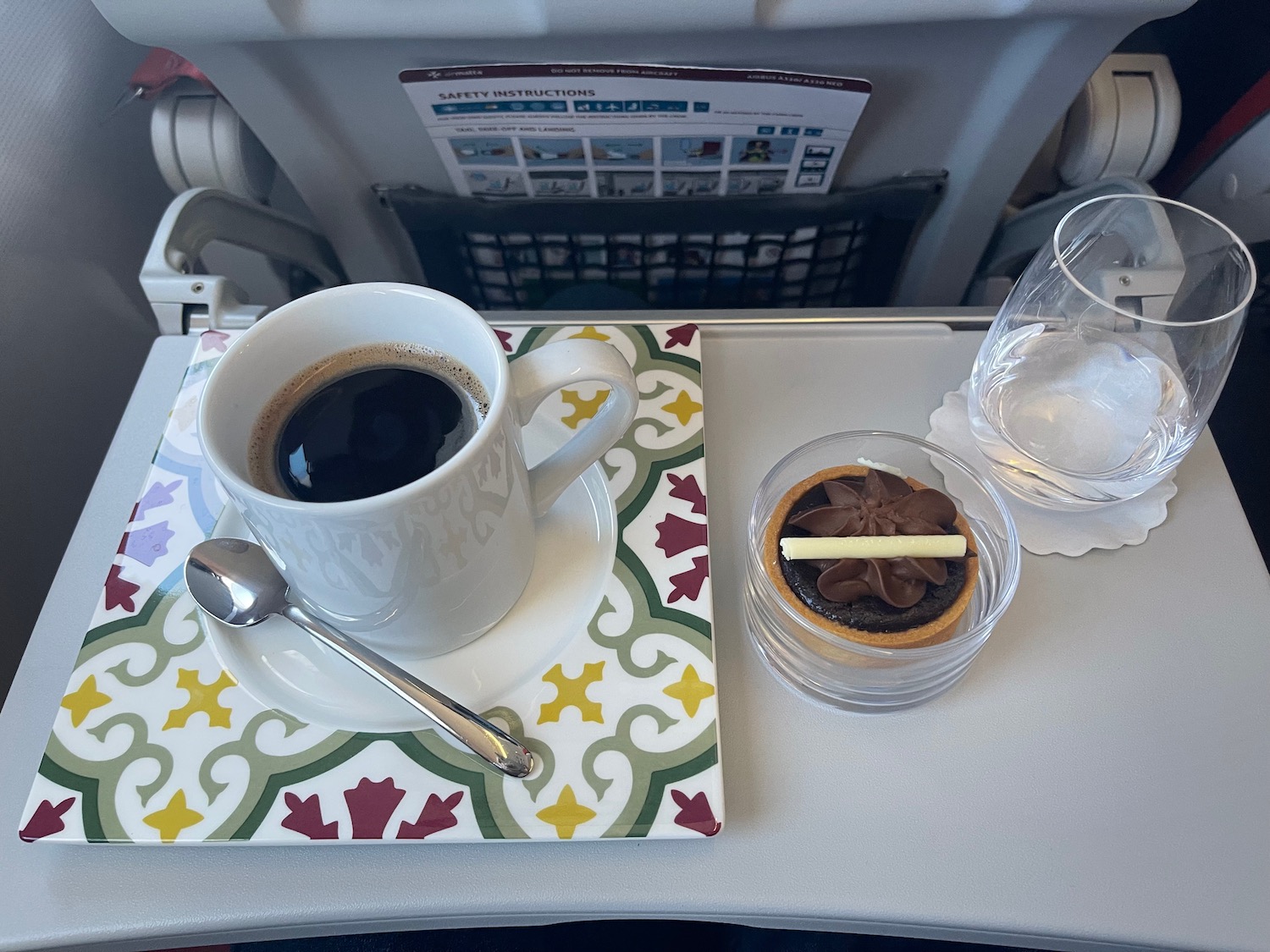 a tray with a cup of coffee and a small cake on it