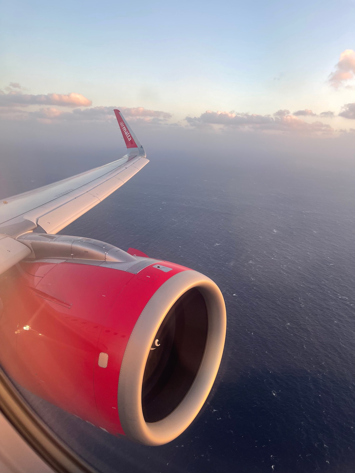 an airplane wing with the ocean in the background