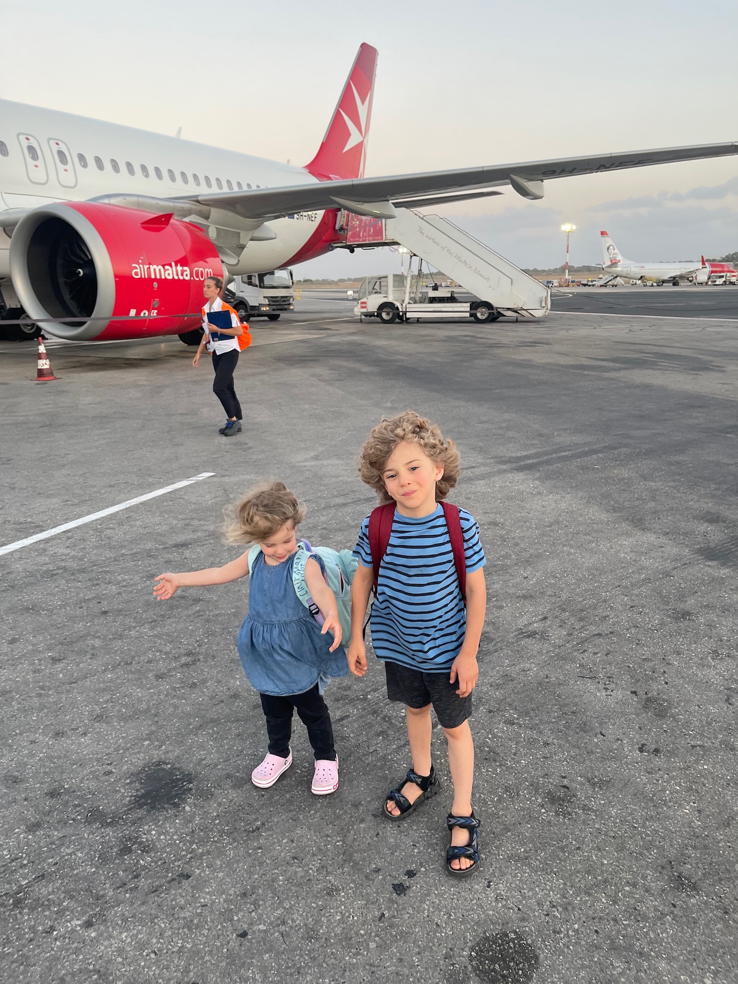 a boy and girl standing in front of an airplane