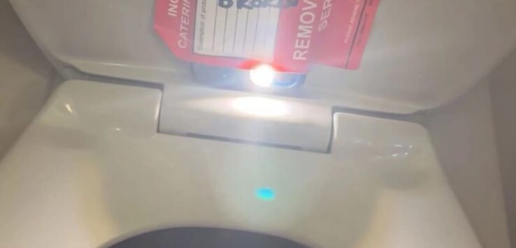 a toilet with red tickets on the lid