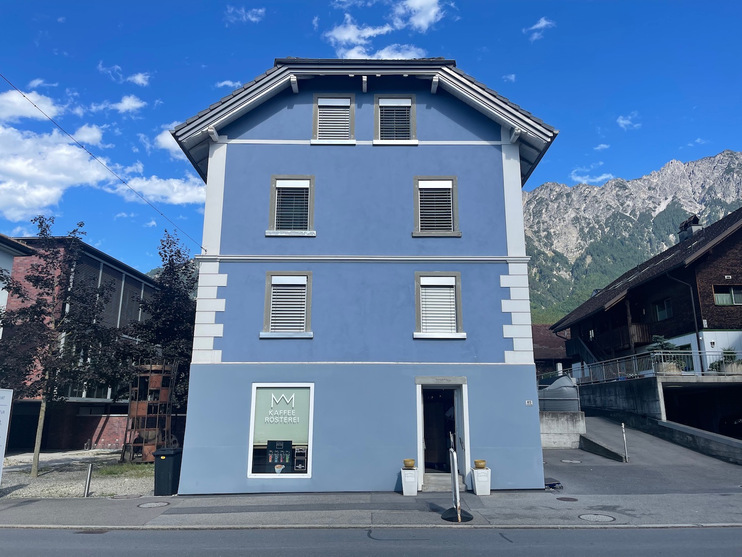 a blue building with a mountain in the background