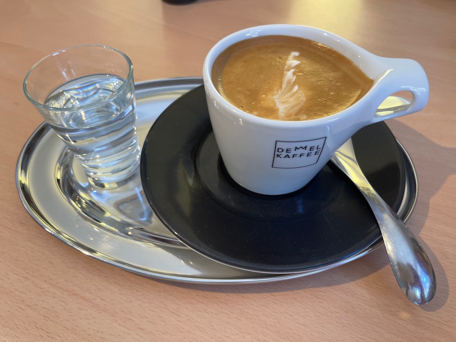 a cup of coffee and a glass of water on a plate