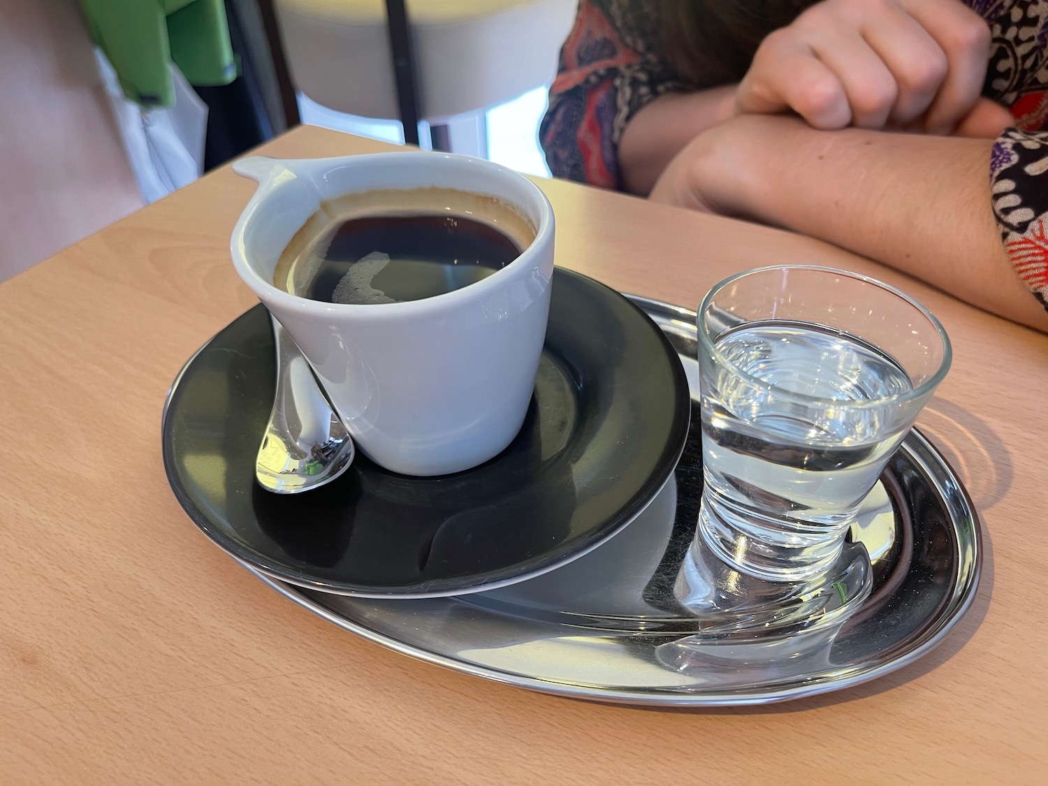a cup of coffee and a glass of water on a tray