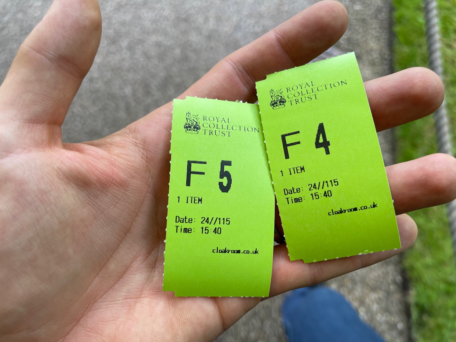 a hand holding two green tickets