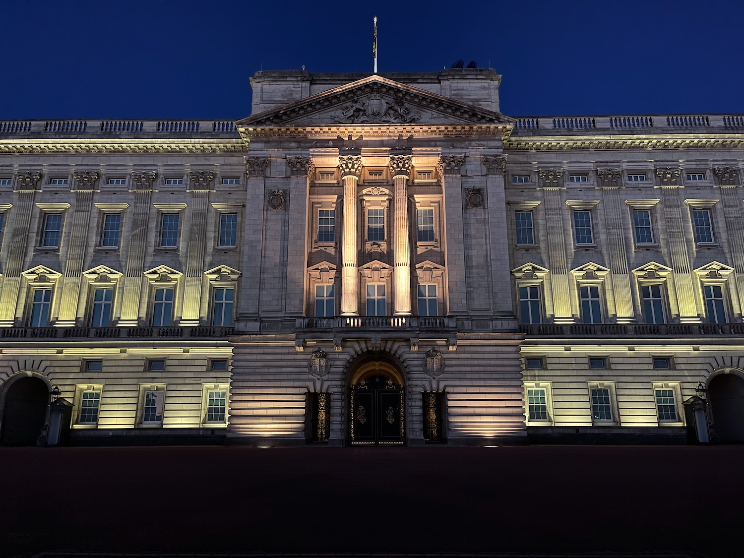 a large building with lights on with Buckingham Palace in the background