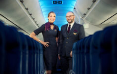 a man and woman standing in an airplane