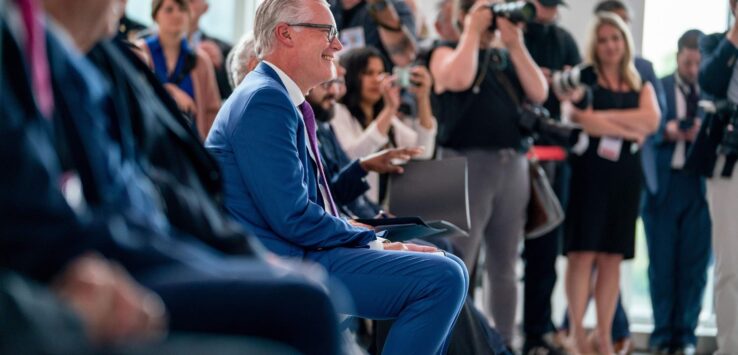 a man in a suit sitting in a crowd