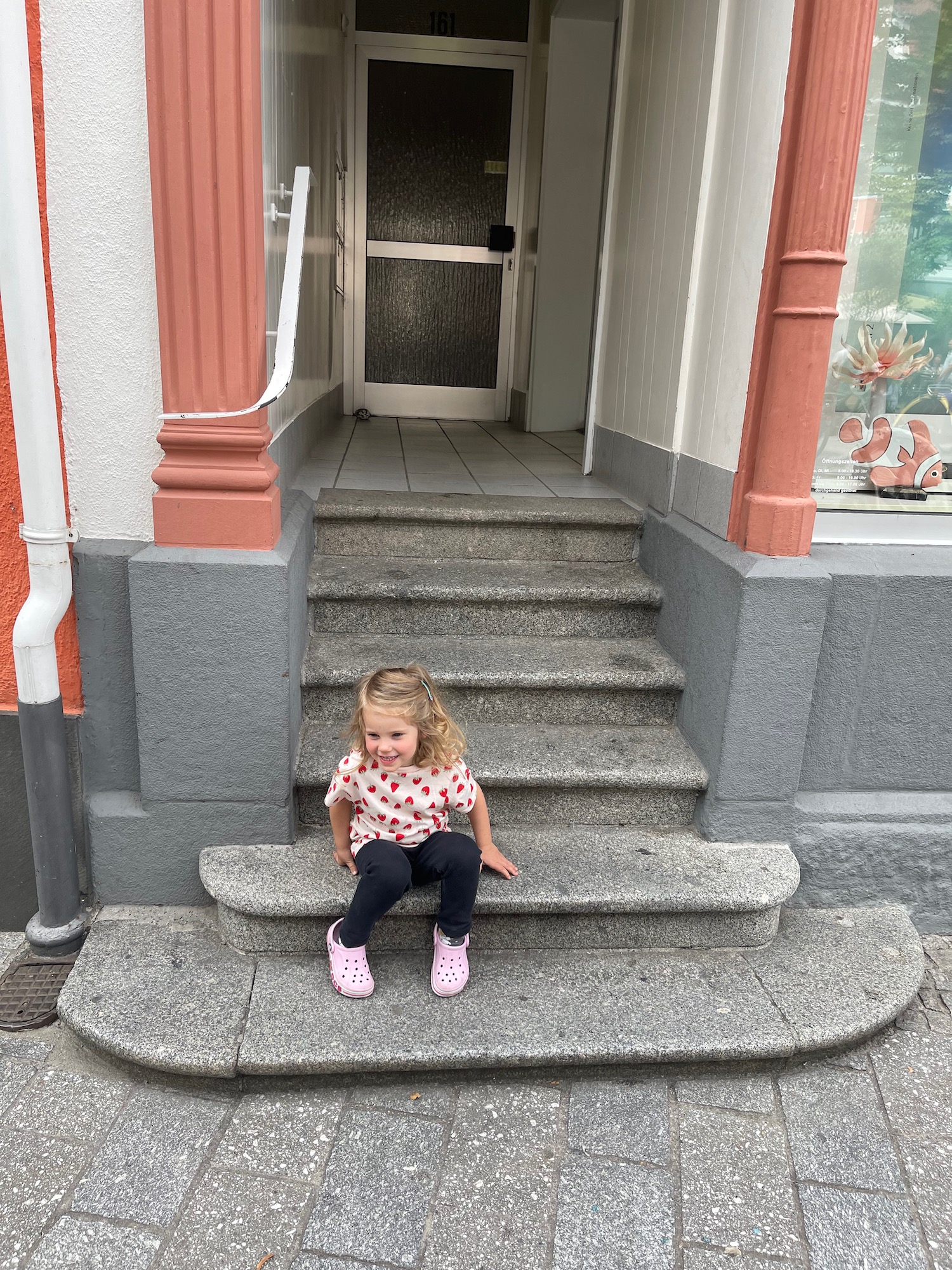 a girl sitting on stairs outside a building