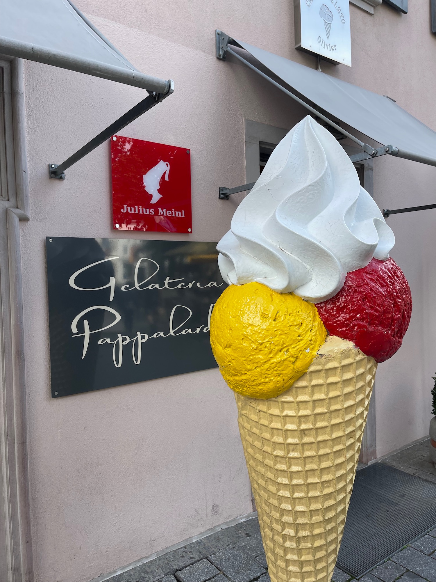 a large ice cream cone with a sign in the background