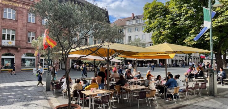 a group of people sitting at tables under a canopy