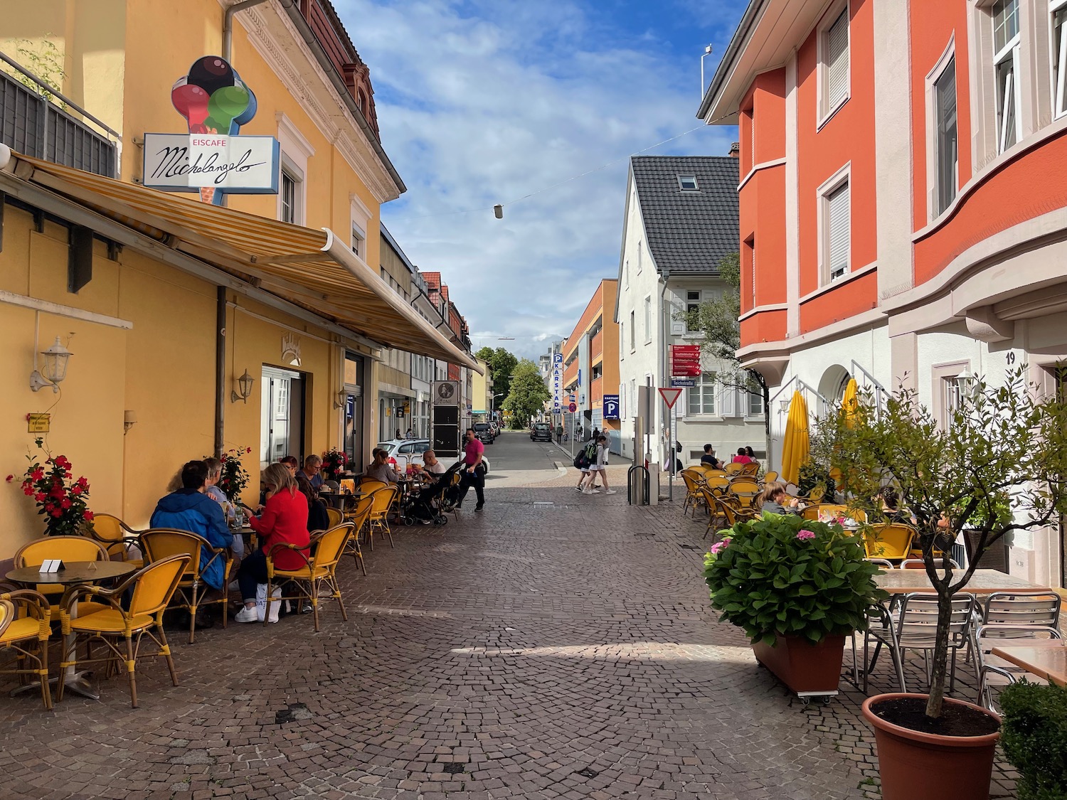 a group of people sitting at tables outside a building