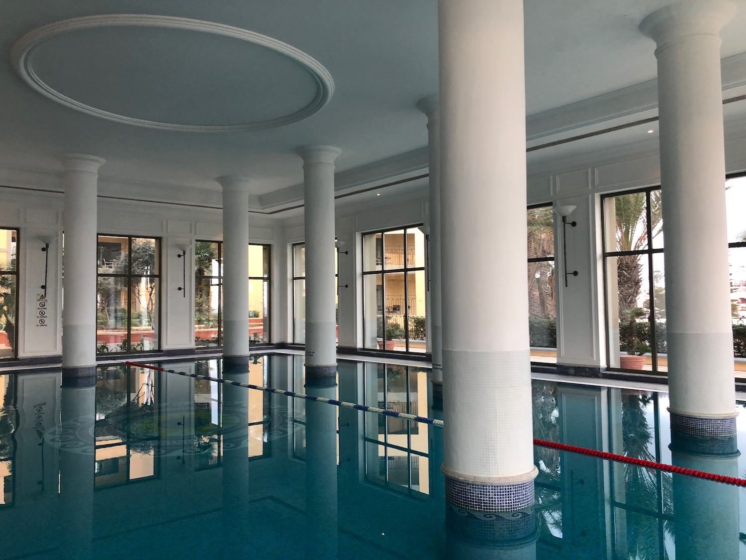 a large indoor pool with columns and windows