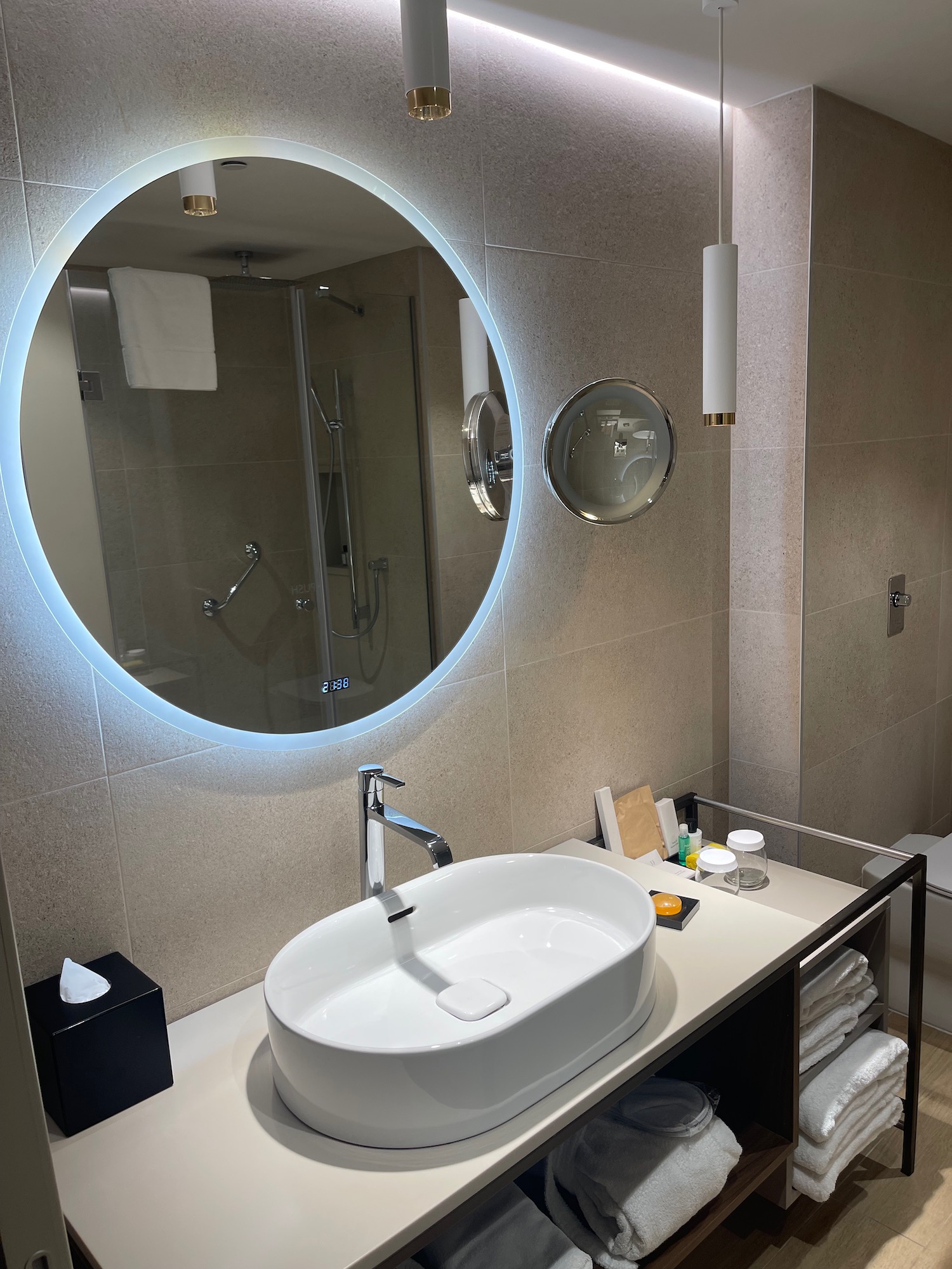 a bathroom with a round mirror and sink