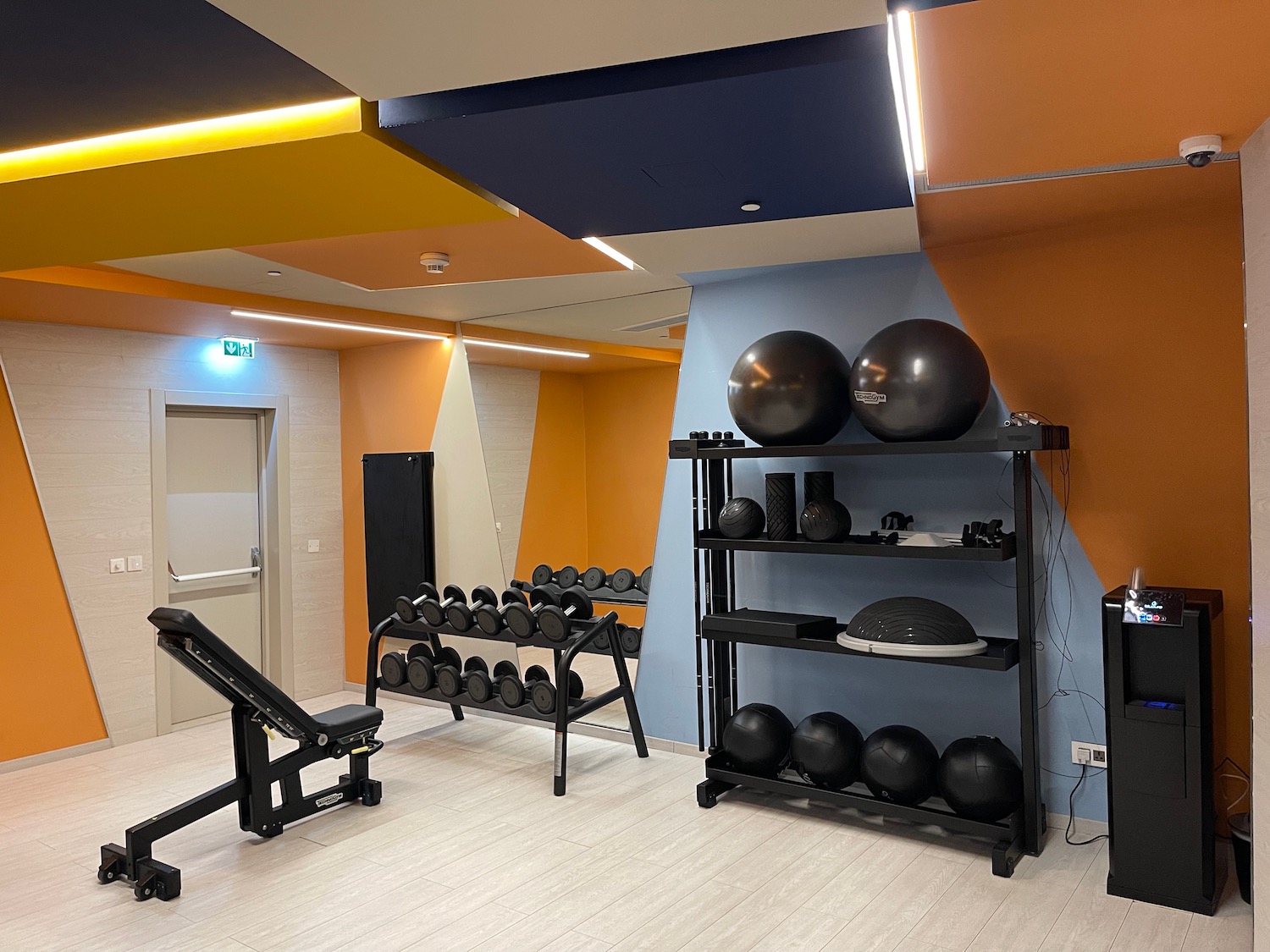 a room with exercise equipment and a shelf with weights