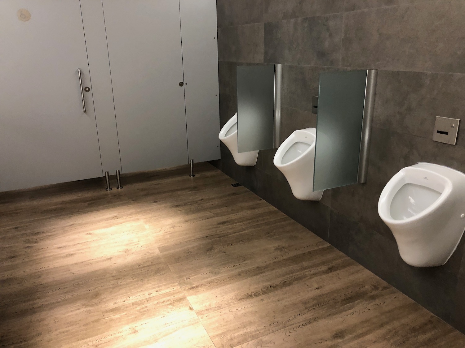a bathroom with urinals and doors