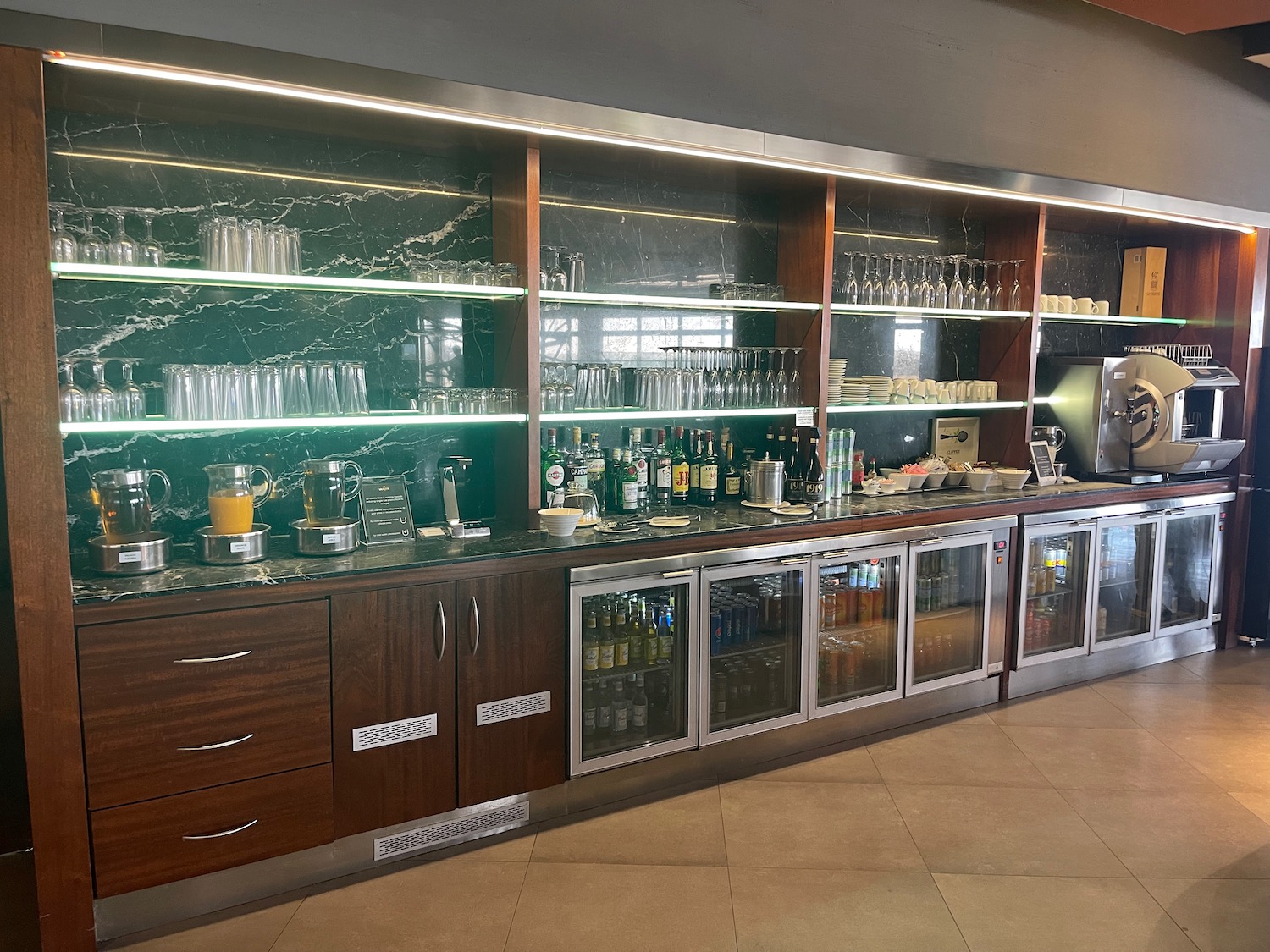 a bar with drinks and glasses on shelves