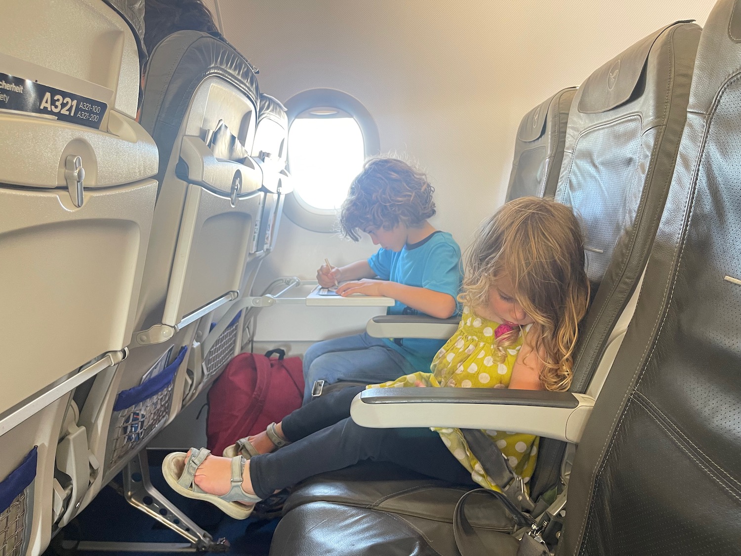 a boy and girl sitting in an airplane