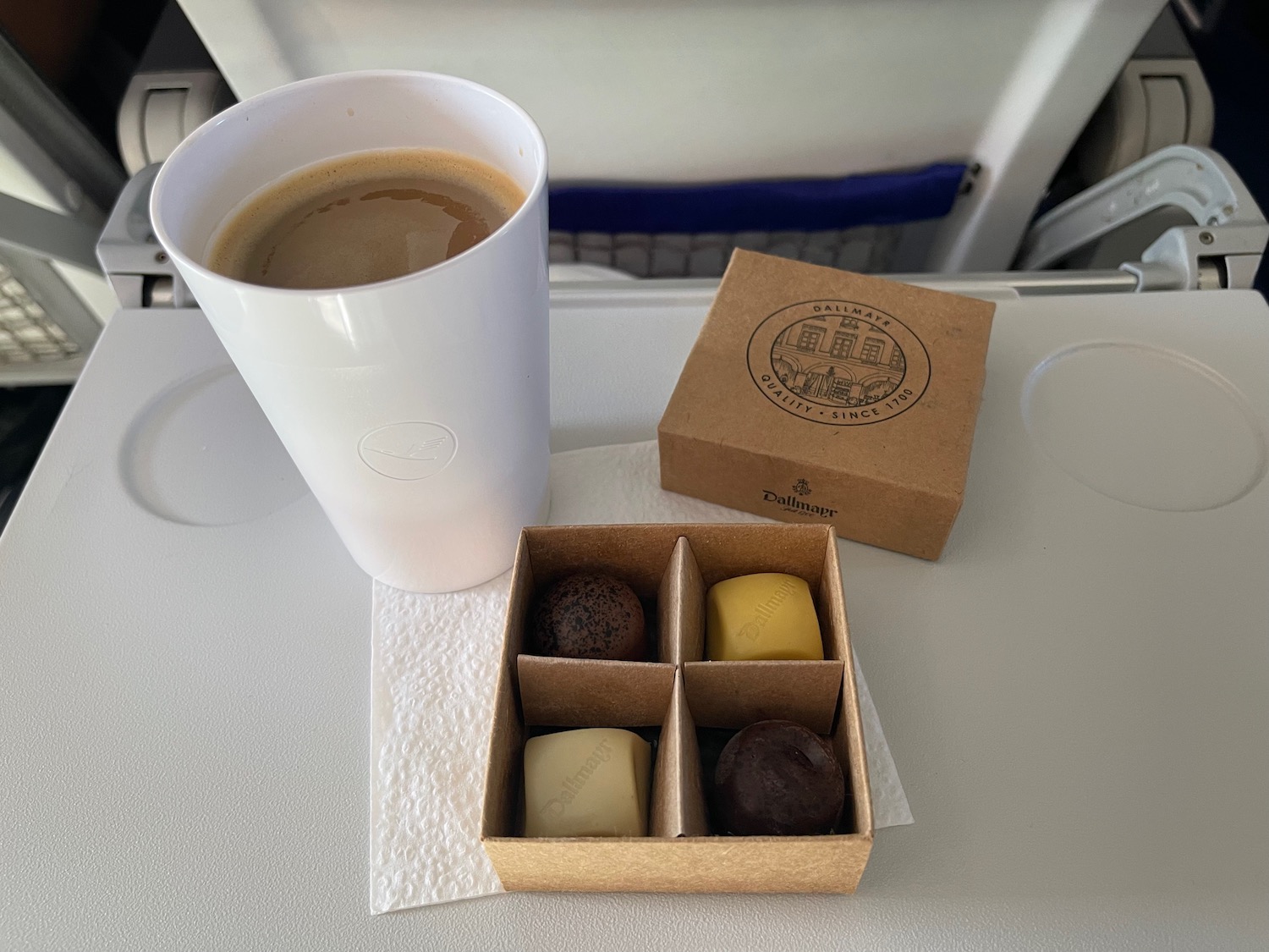a cup of coffee and chocolates on a table