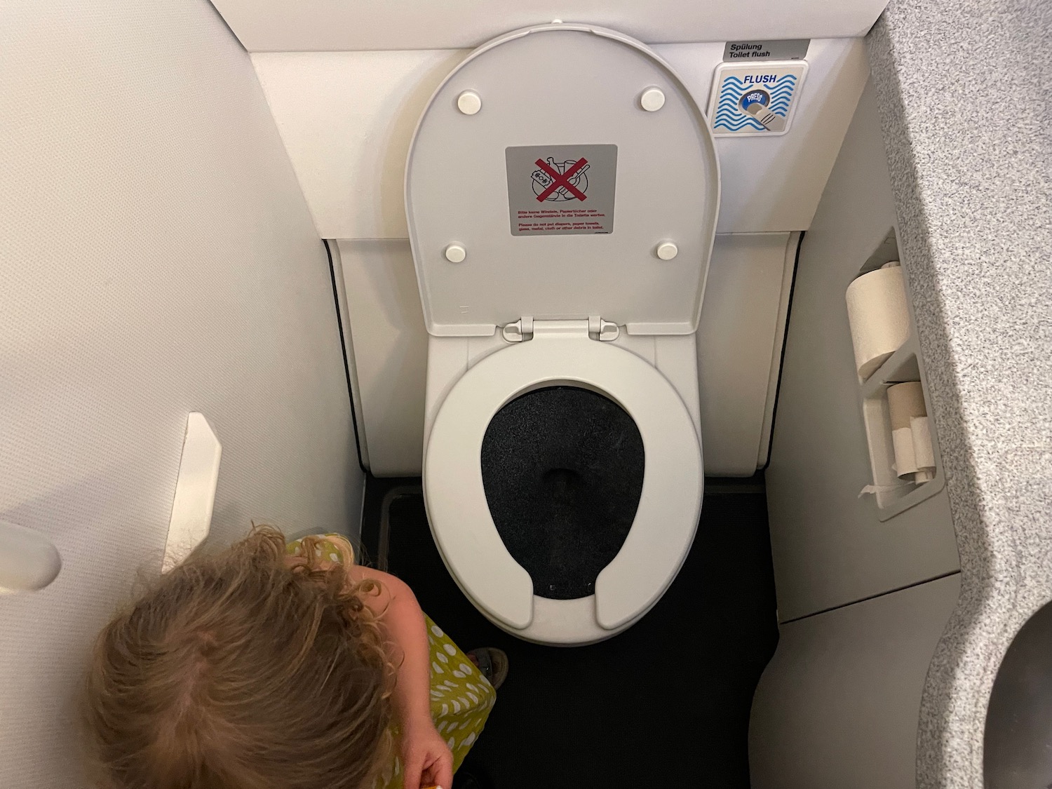a child looking at a toilet