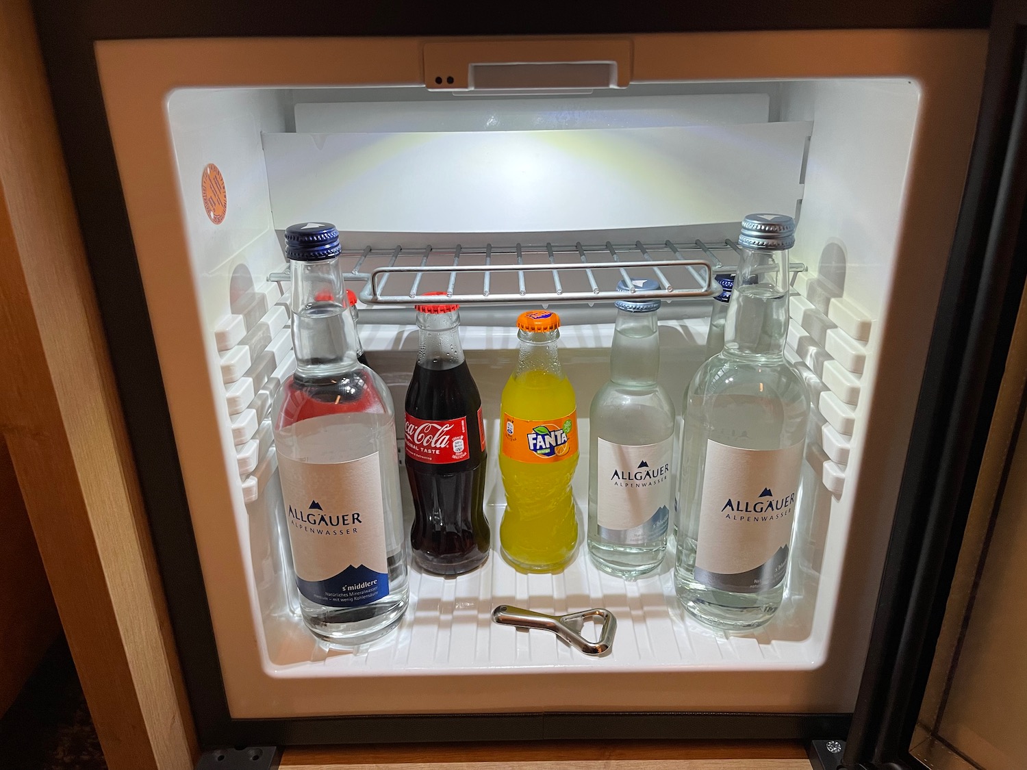 a mini fridge with bottles of soda and a key