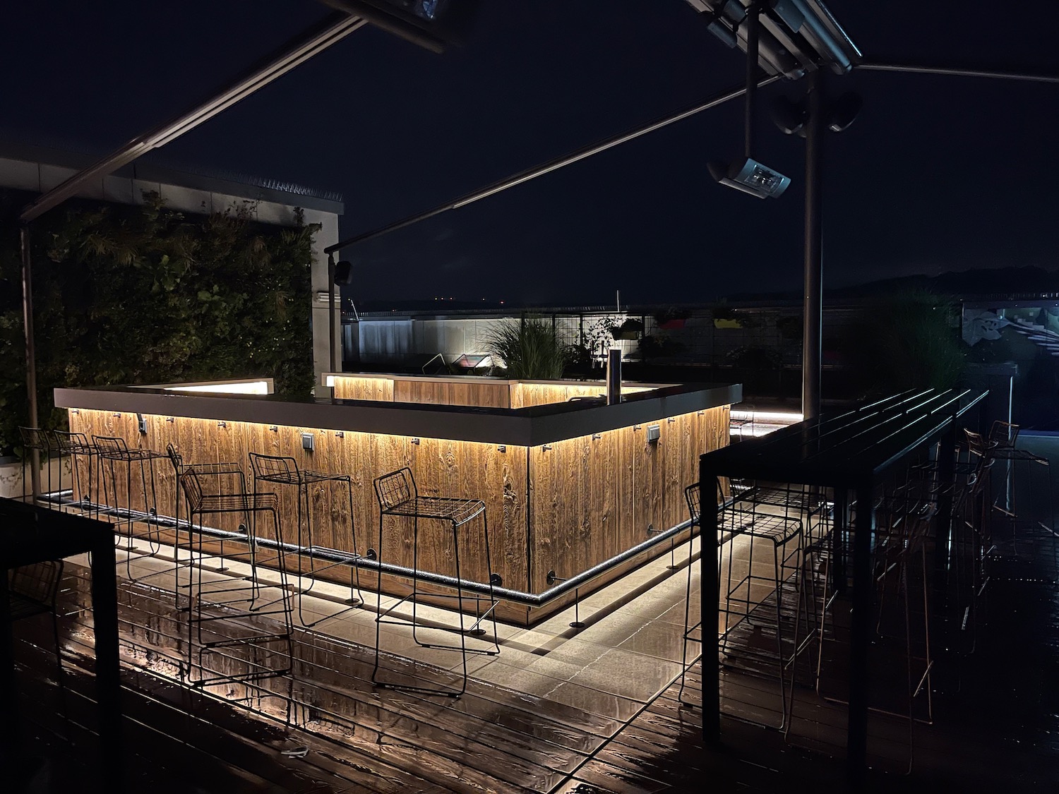 a bar with chairs and lights at night