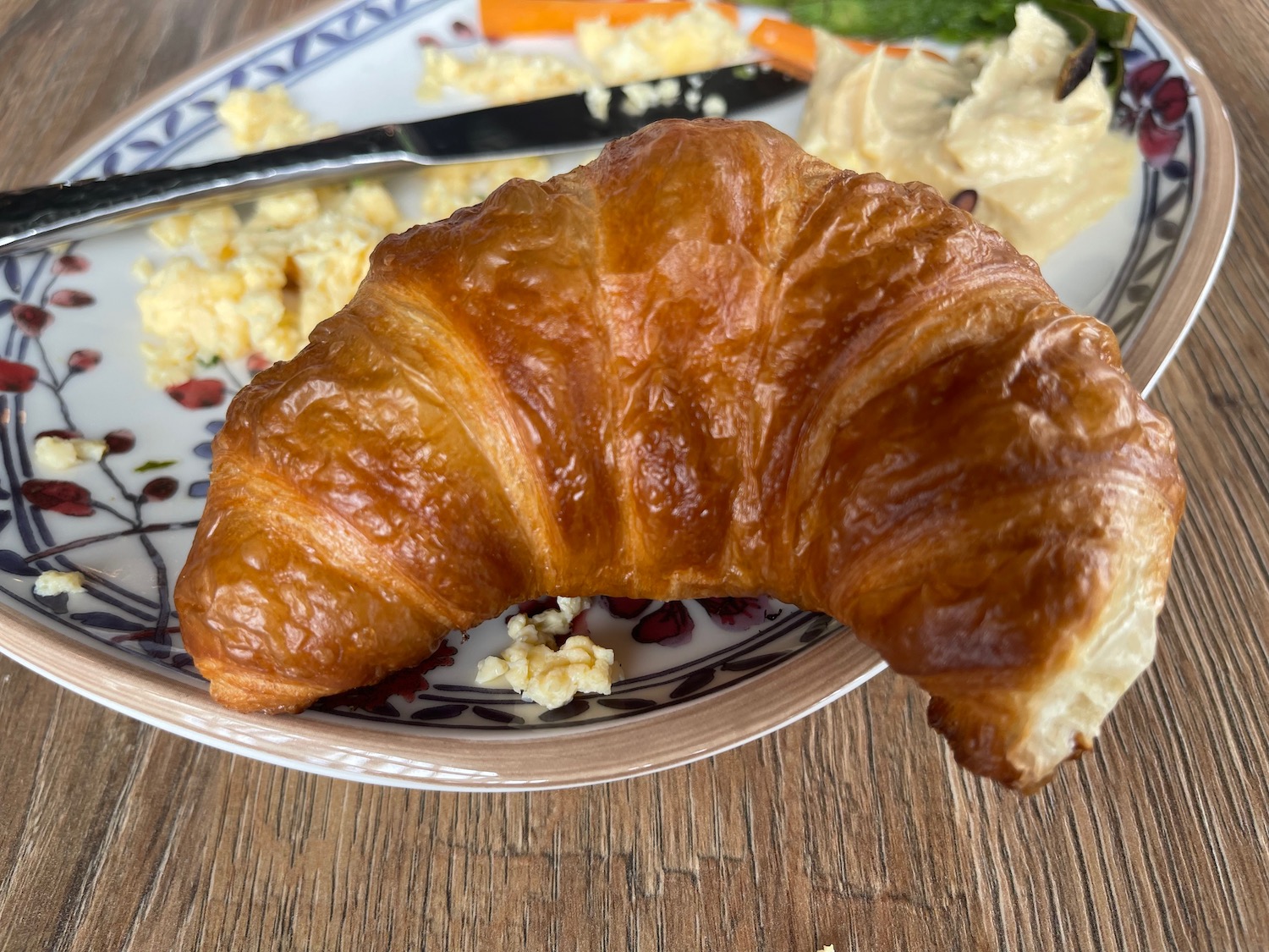 a croissant on a plate with a knife and fork