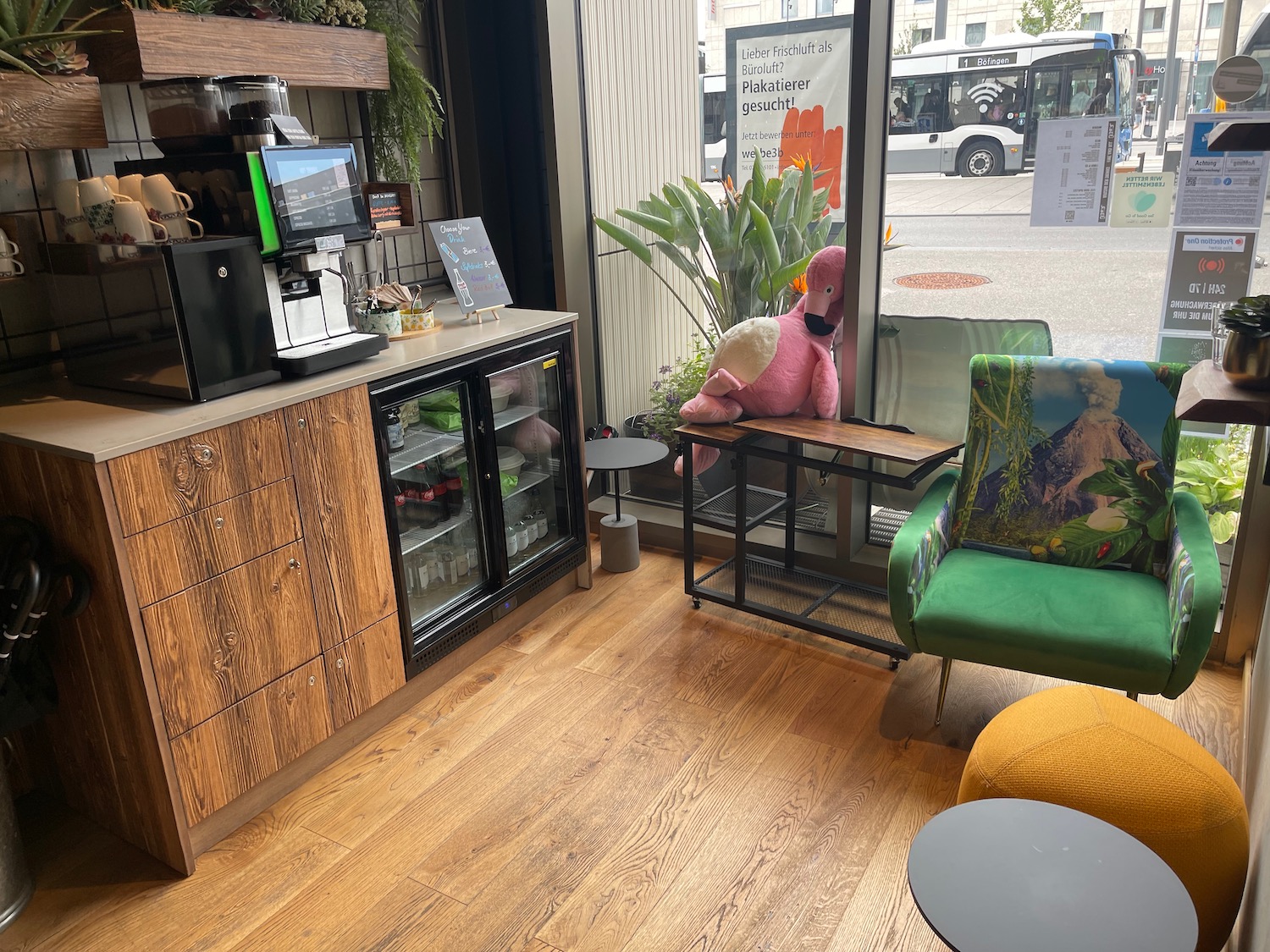 a room with a pink flamingo on a table and green chairs