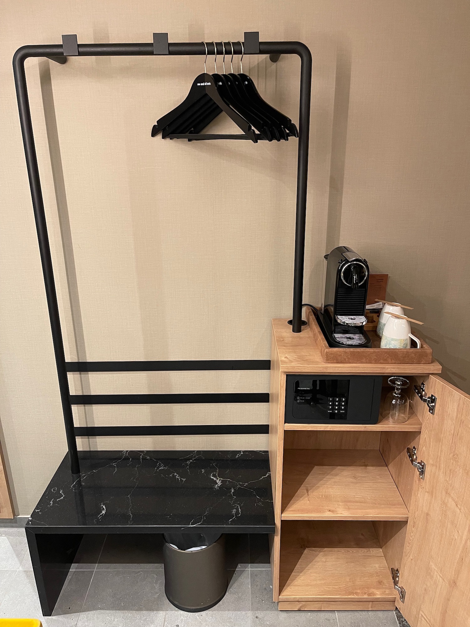 a black and wood shelf with a black coat rack and a black coat swinger