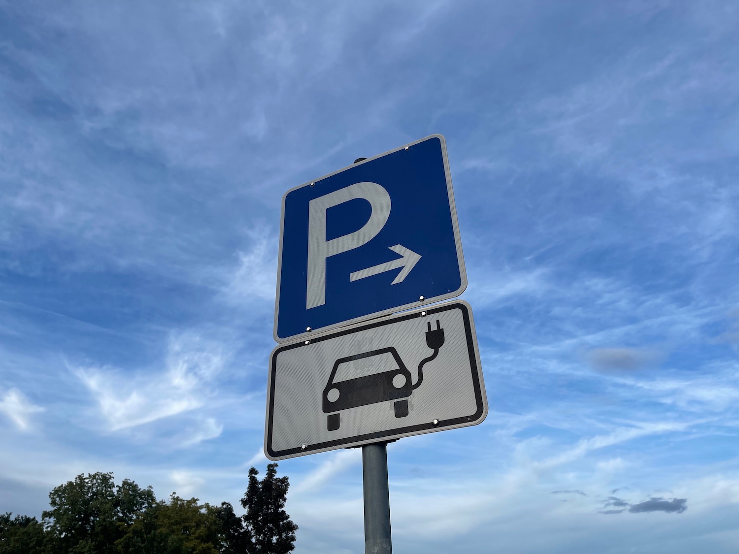 a blue and white sign with a car and an arrow