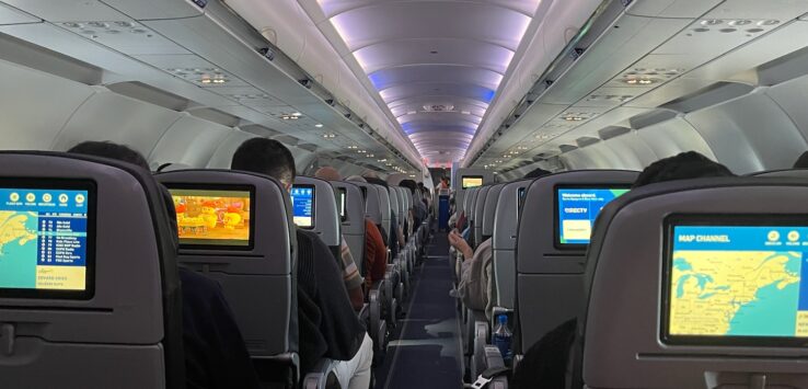 a row of seats with monitors on the back