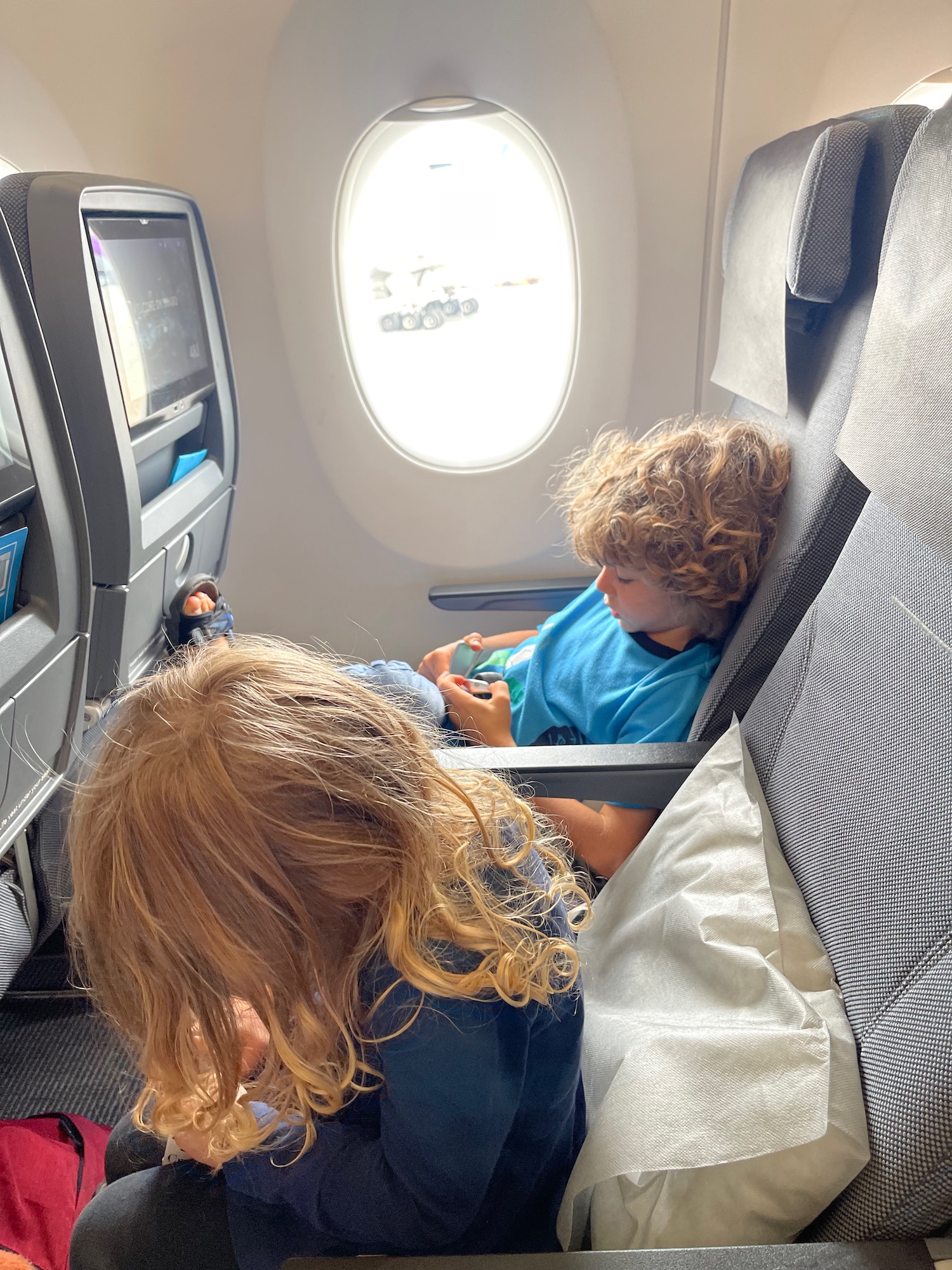 a boy and girl sitting in an airplane