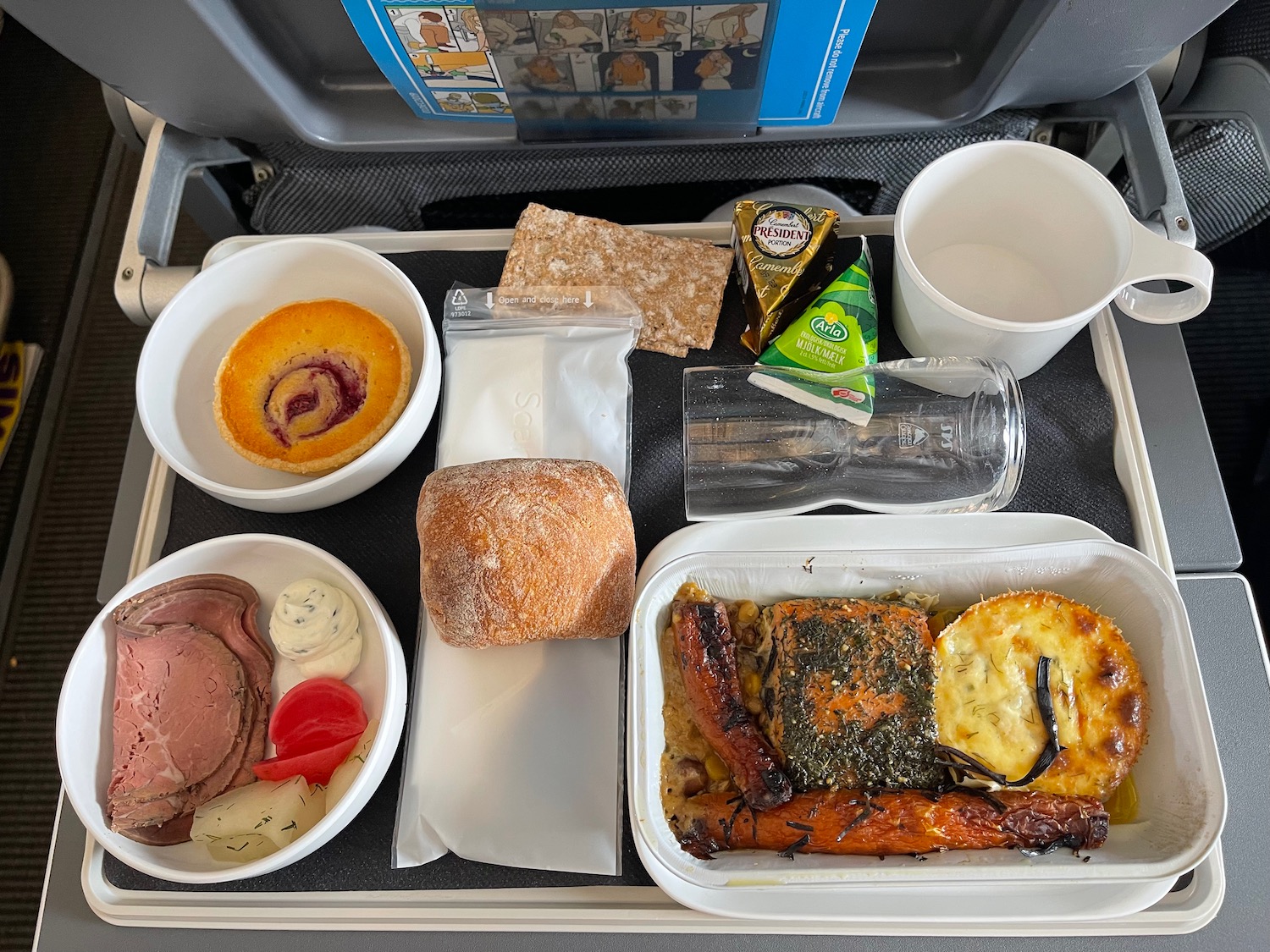 food on a tray with a couple of cups and a glass