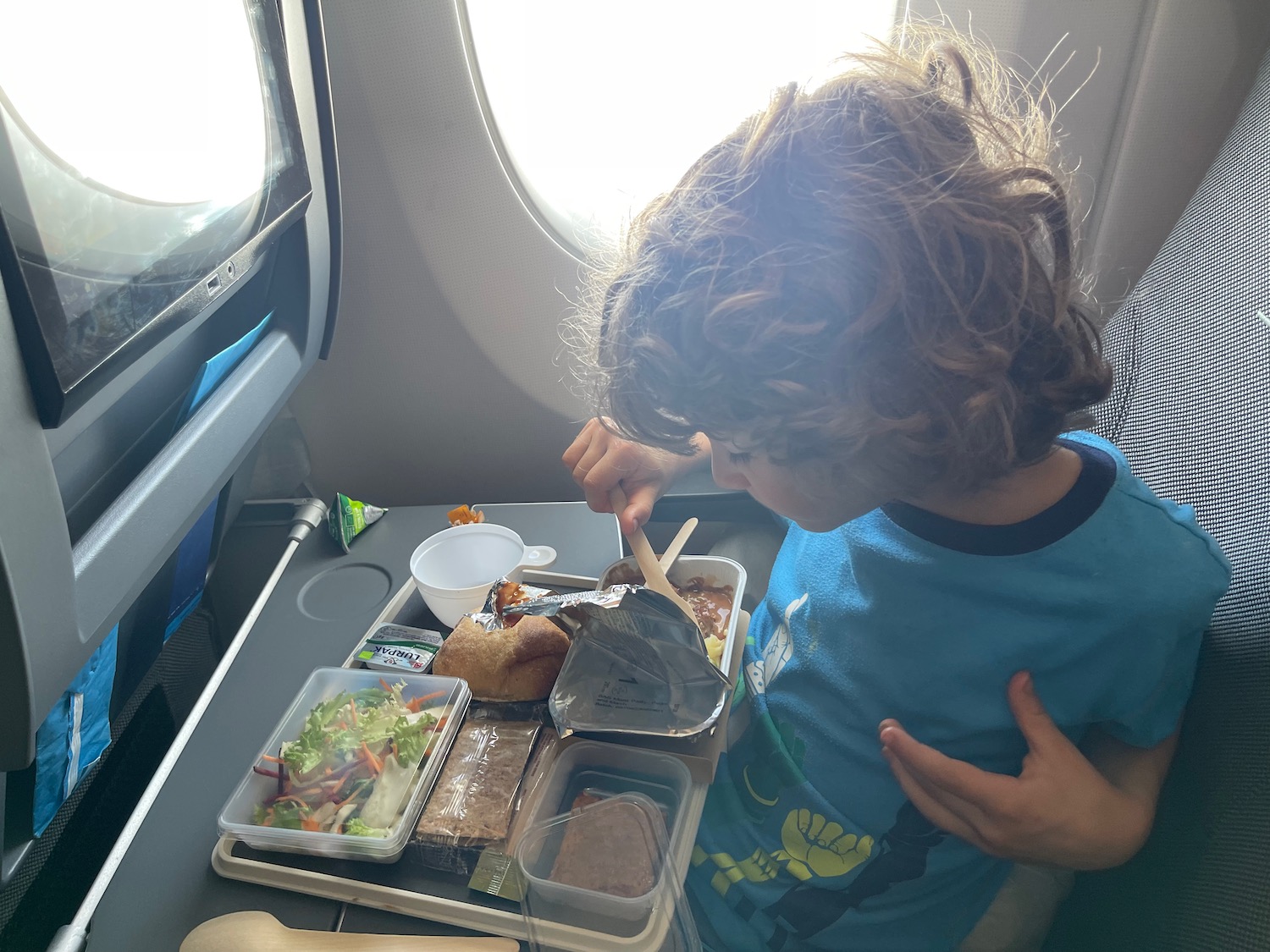 a child eating food on an airplane