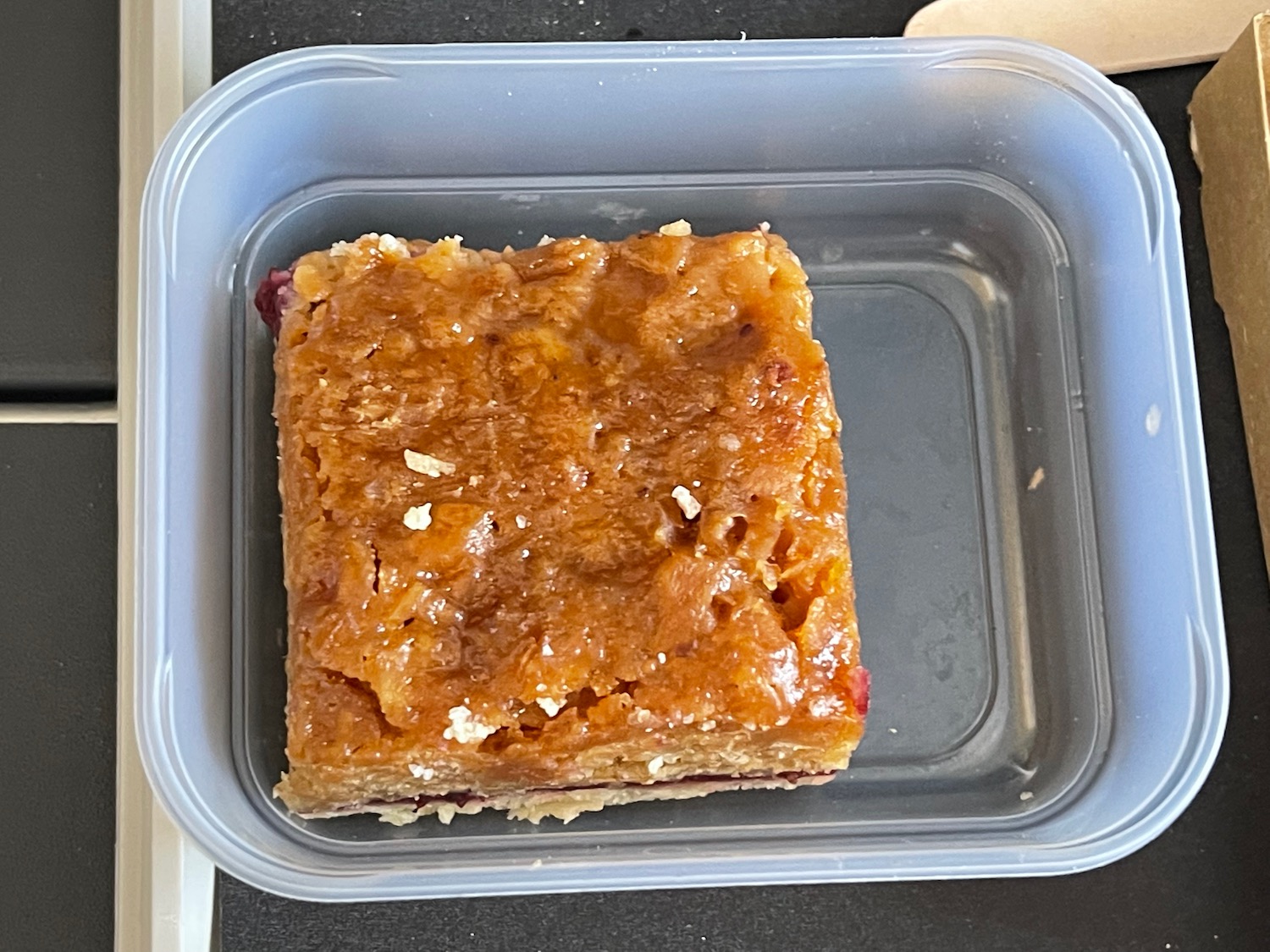 a square brown food in a plastic container