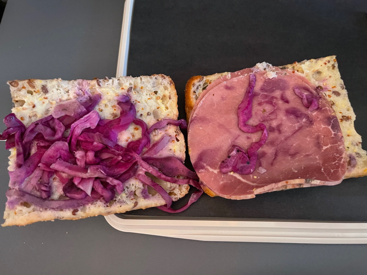 a sandwich with meat and onions on a tray