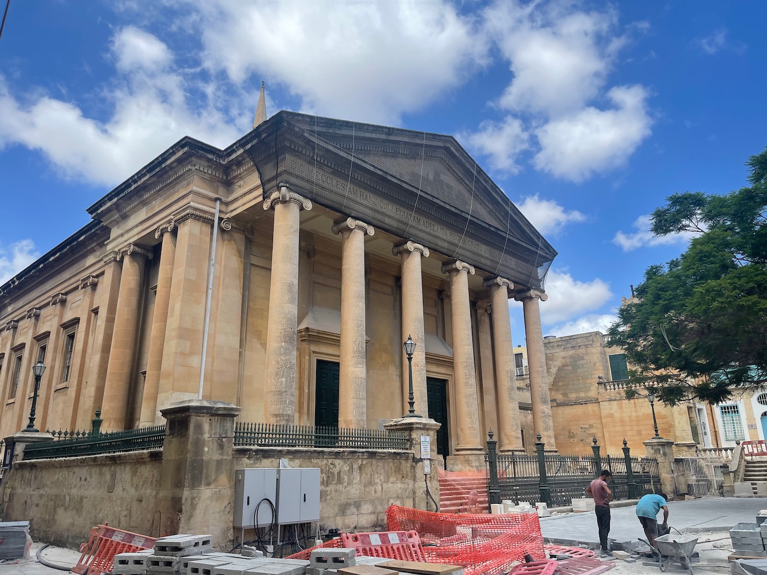 a building with pillars and a fence