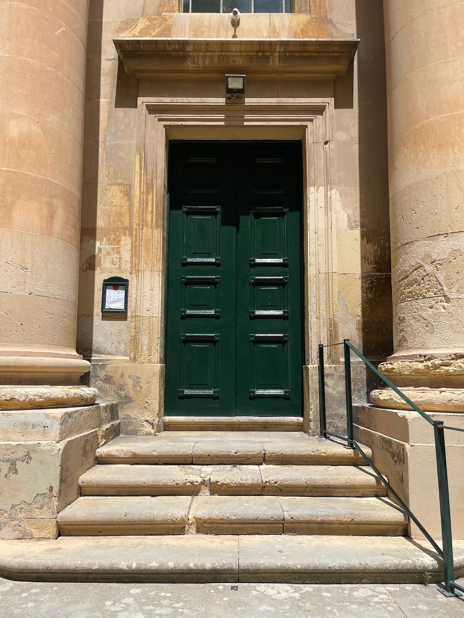 a green door with steps leading up to a building