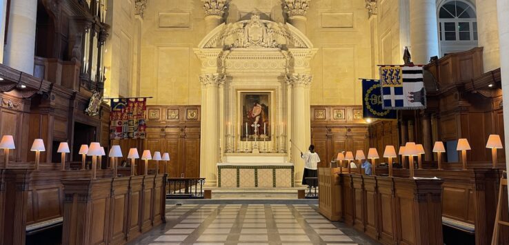 a room with a large wall and a man standing in front of a statue