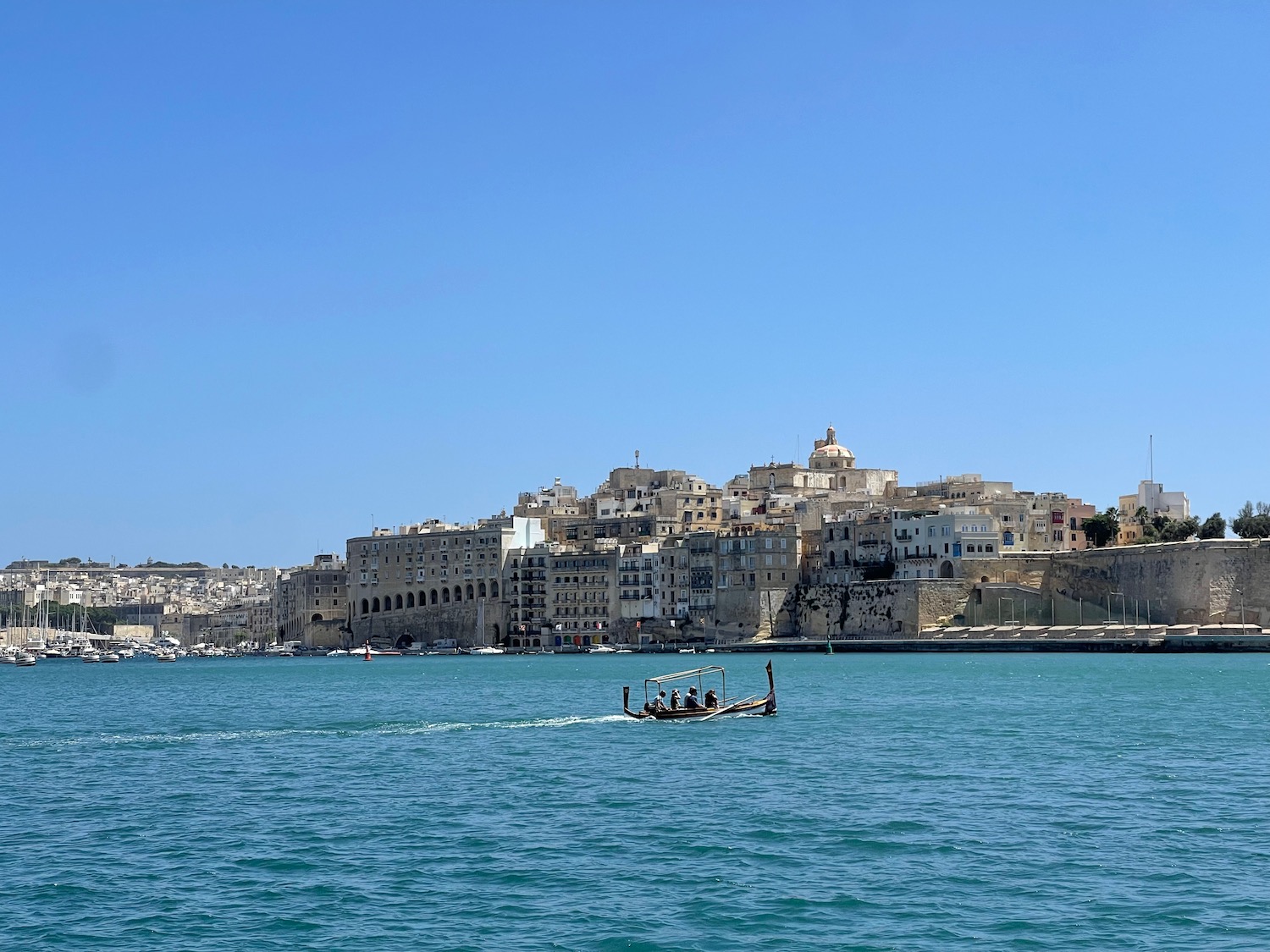 a boat in the water with buildings in the background