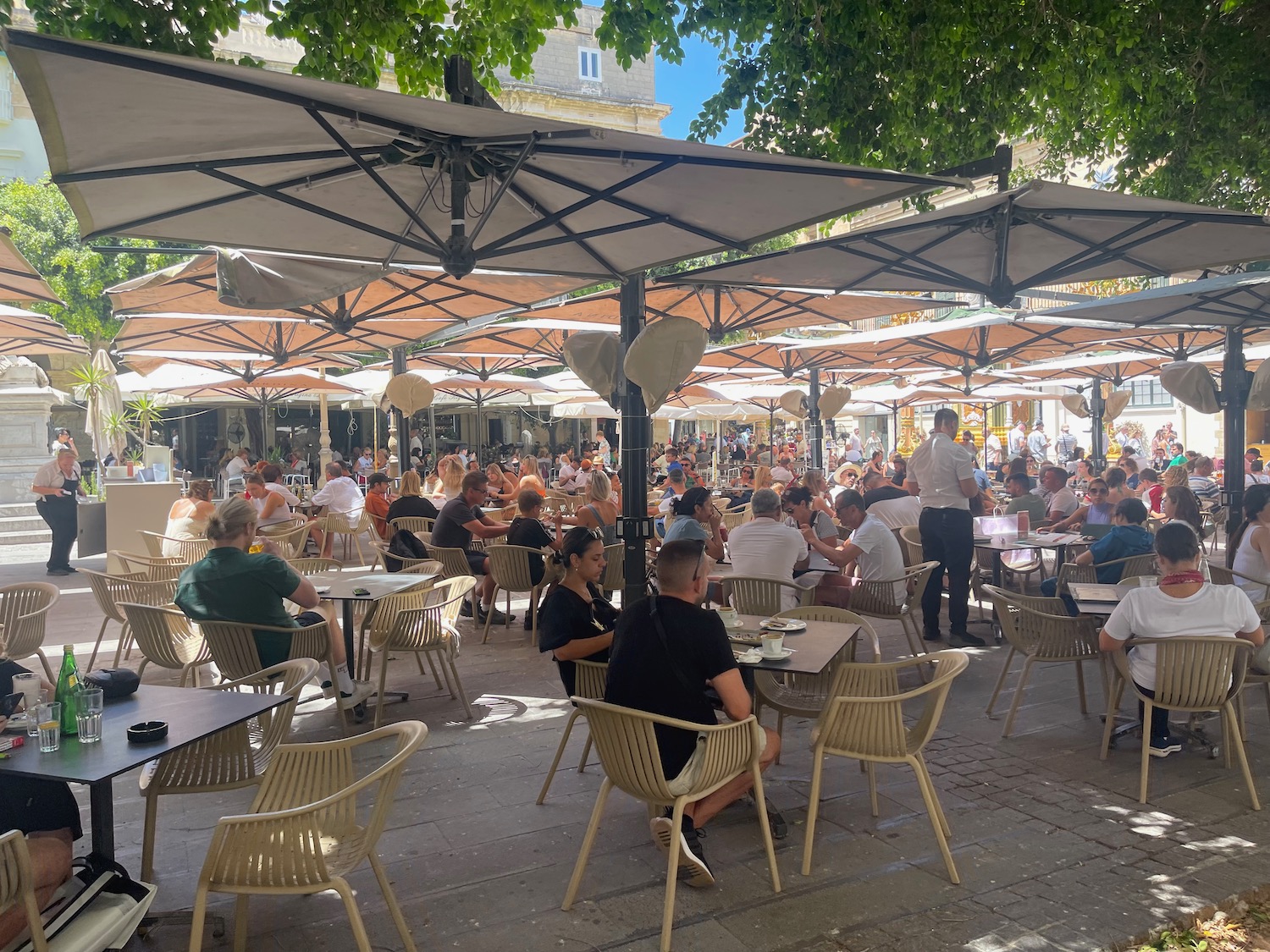 a group of people sitting at tables outside