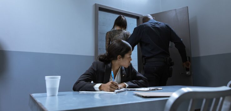 a woman sitting at a table with a man standing behind her